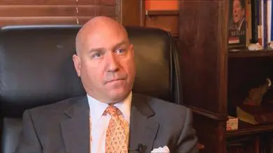 Man in suit sitting in an office chair.